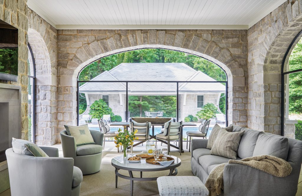 Stone loggia with arched openings and grey outdoor seating