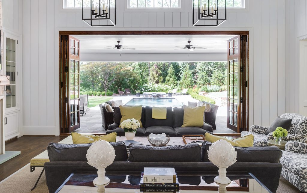 Living room opening to a pool through wide sliding doors