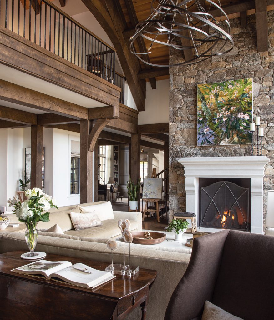 Two-story living room with timber beams and a stone fireplace