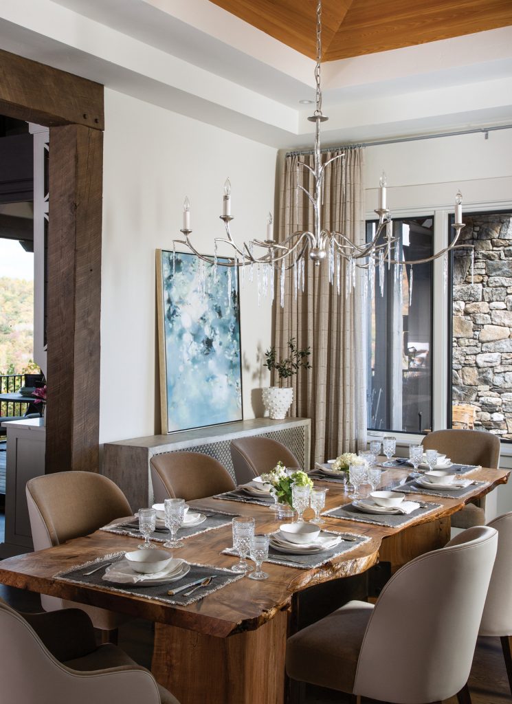 Dining room with a wood table, taupe chairs and a stone wall
