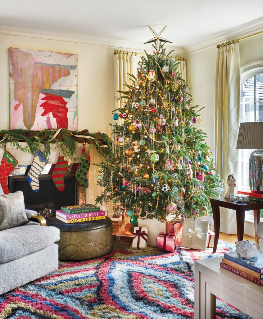 Living room with a decorated tree, braided rug and bright artwork