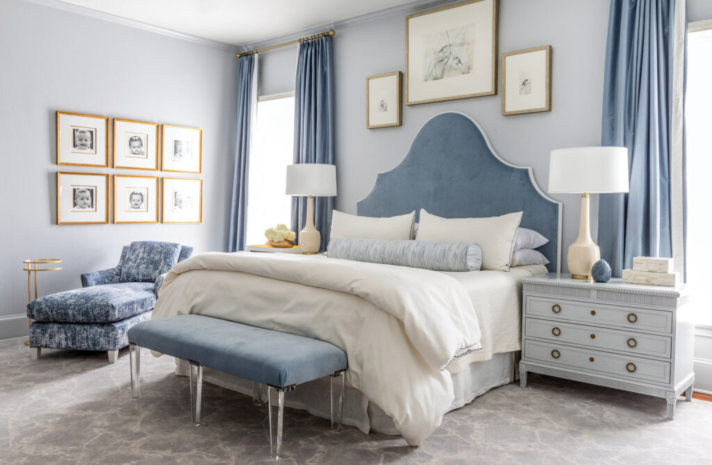 Bedroom with a blue arched headboard, gallery wall and bench