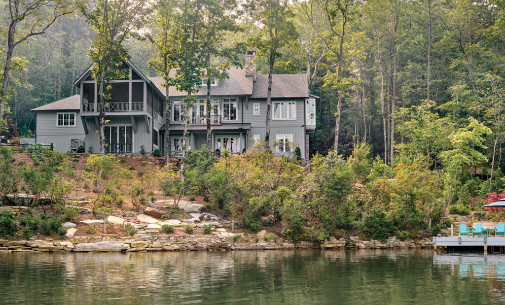 Lakeside houses among wooded slopes above still water