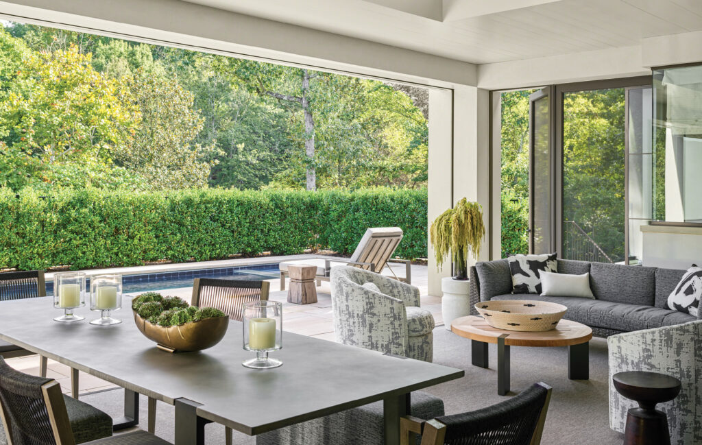 Covered terrace with a long dining table and pale seating