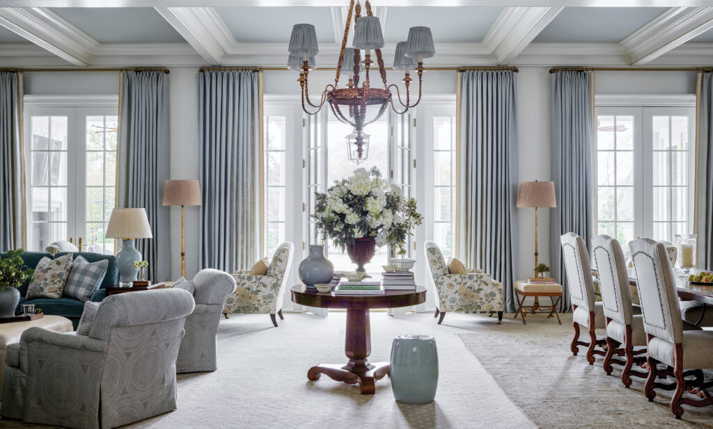 Pale blue sitting room with a chandelier, hydrangeas and grey sofas