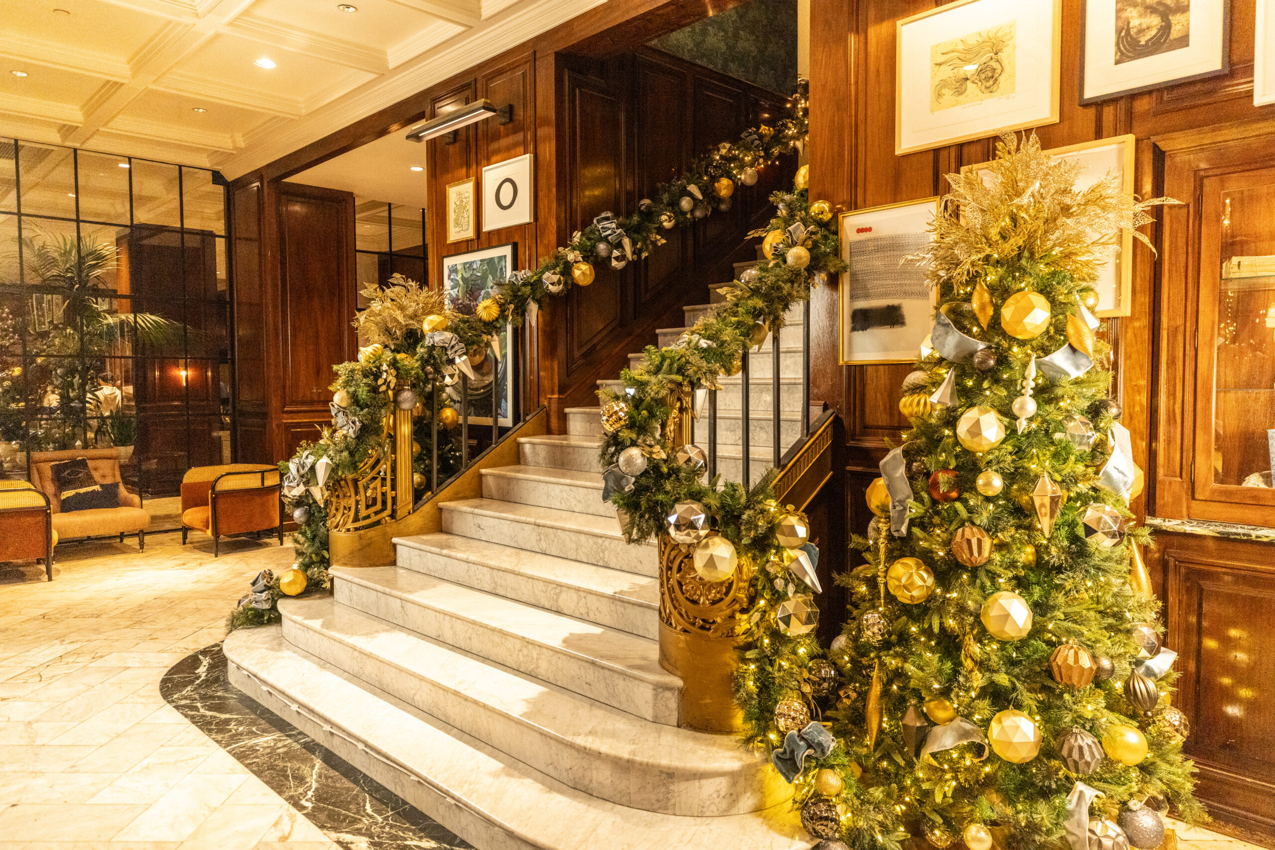 Hotel stair flanked by decorated Christmas trees
