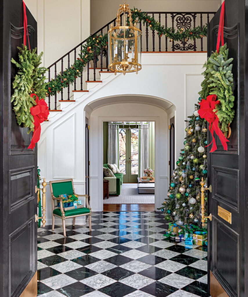 Entry with a checkerboard floor, garlanded stair and decorated tree