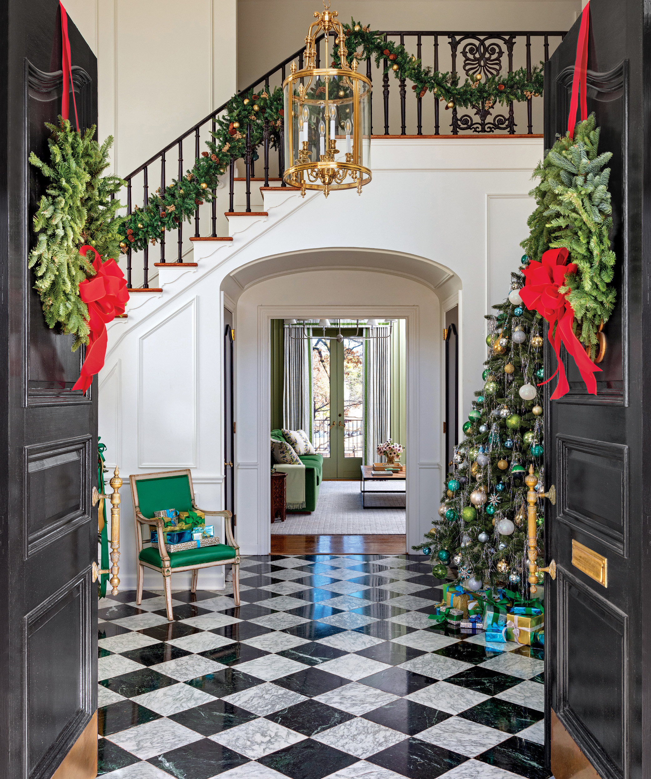 Entry with a checkerboard floor, garlanded stair and decorated tree