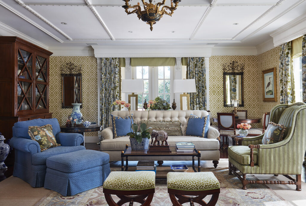 Living room with blue slipcovered chairs and needlepoint stools