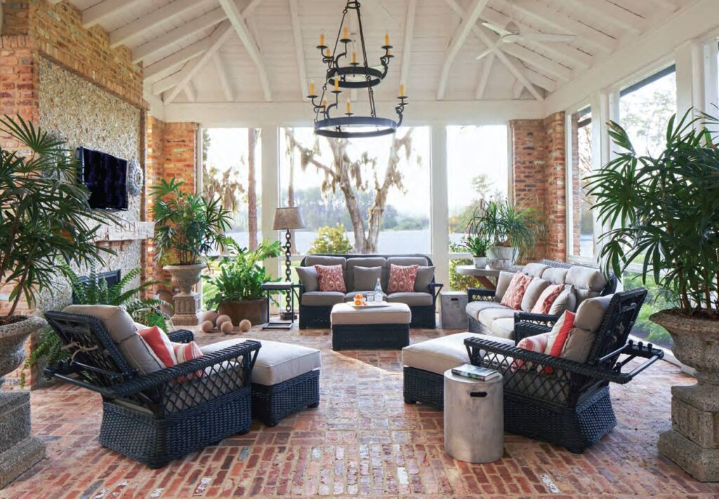 Brick porch with navy wicker seating and an iron chandelier