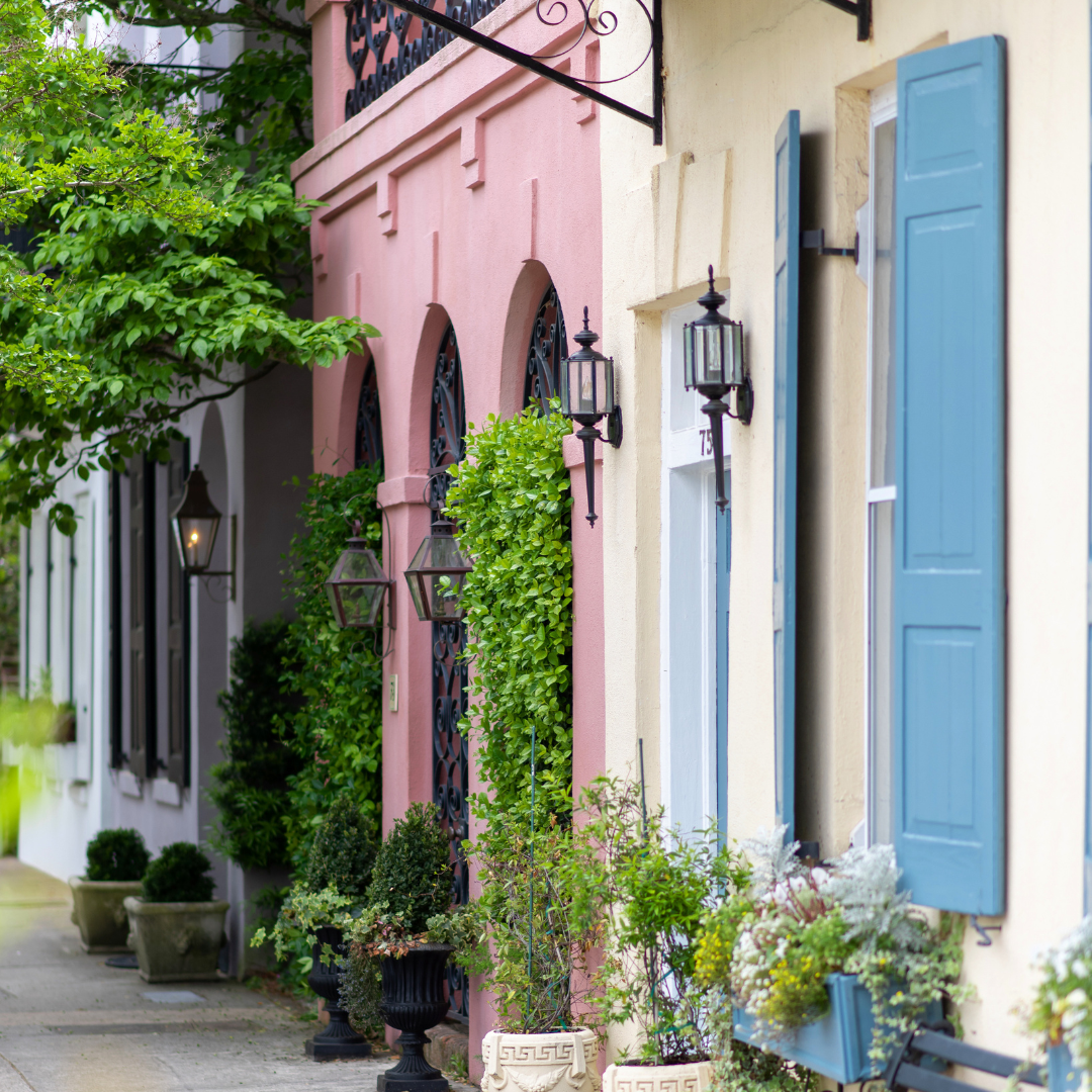 Row of pastel houses with blue shutters and window boxes