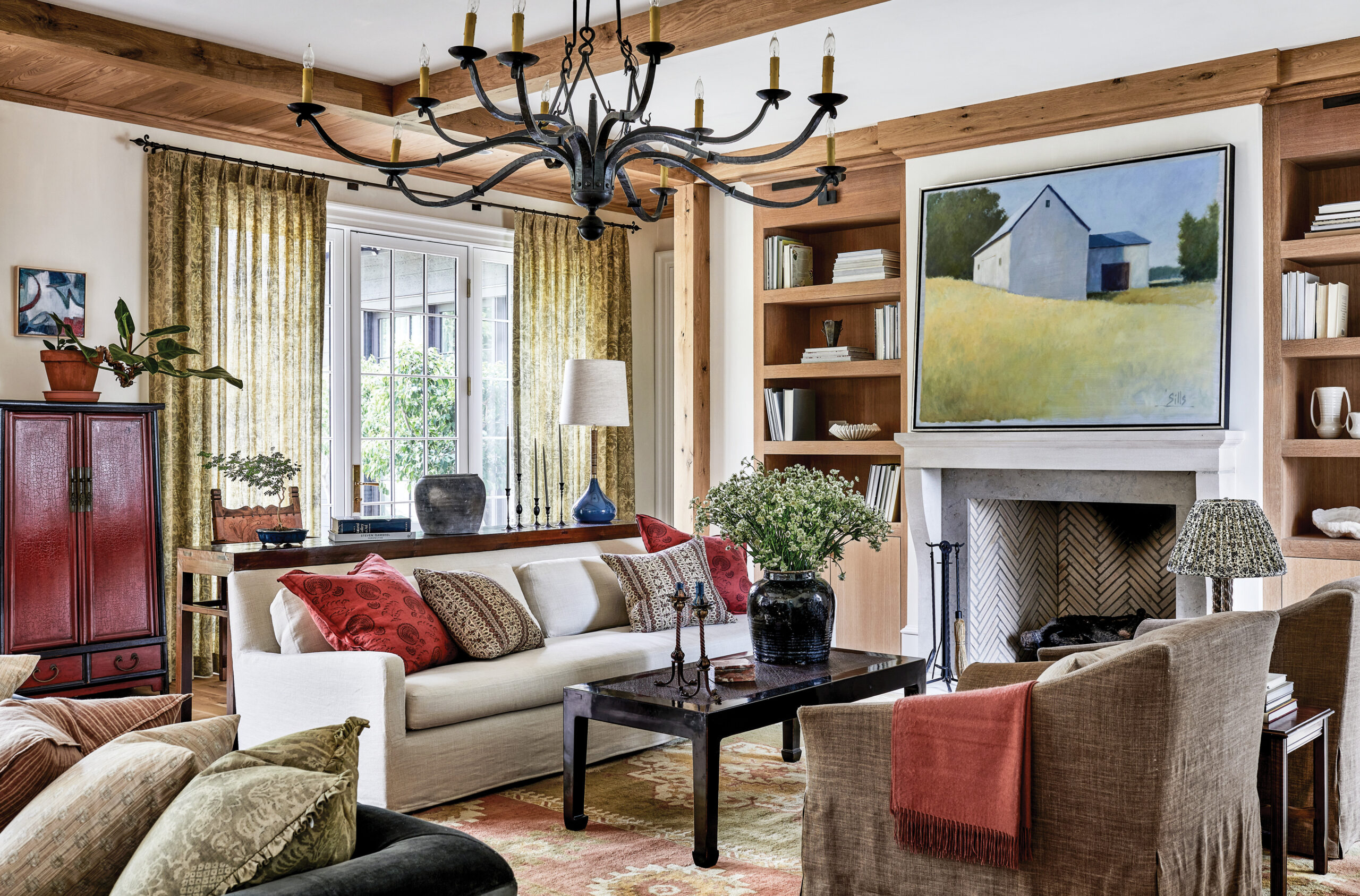Living room with a stone fireplace, red pillows and lacquer cabinet