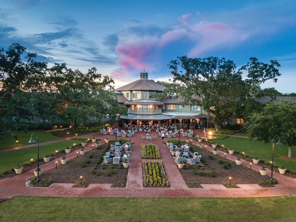 Aerial view of a resort with formal gardens at sunset