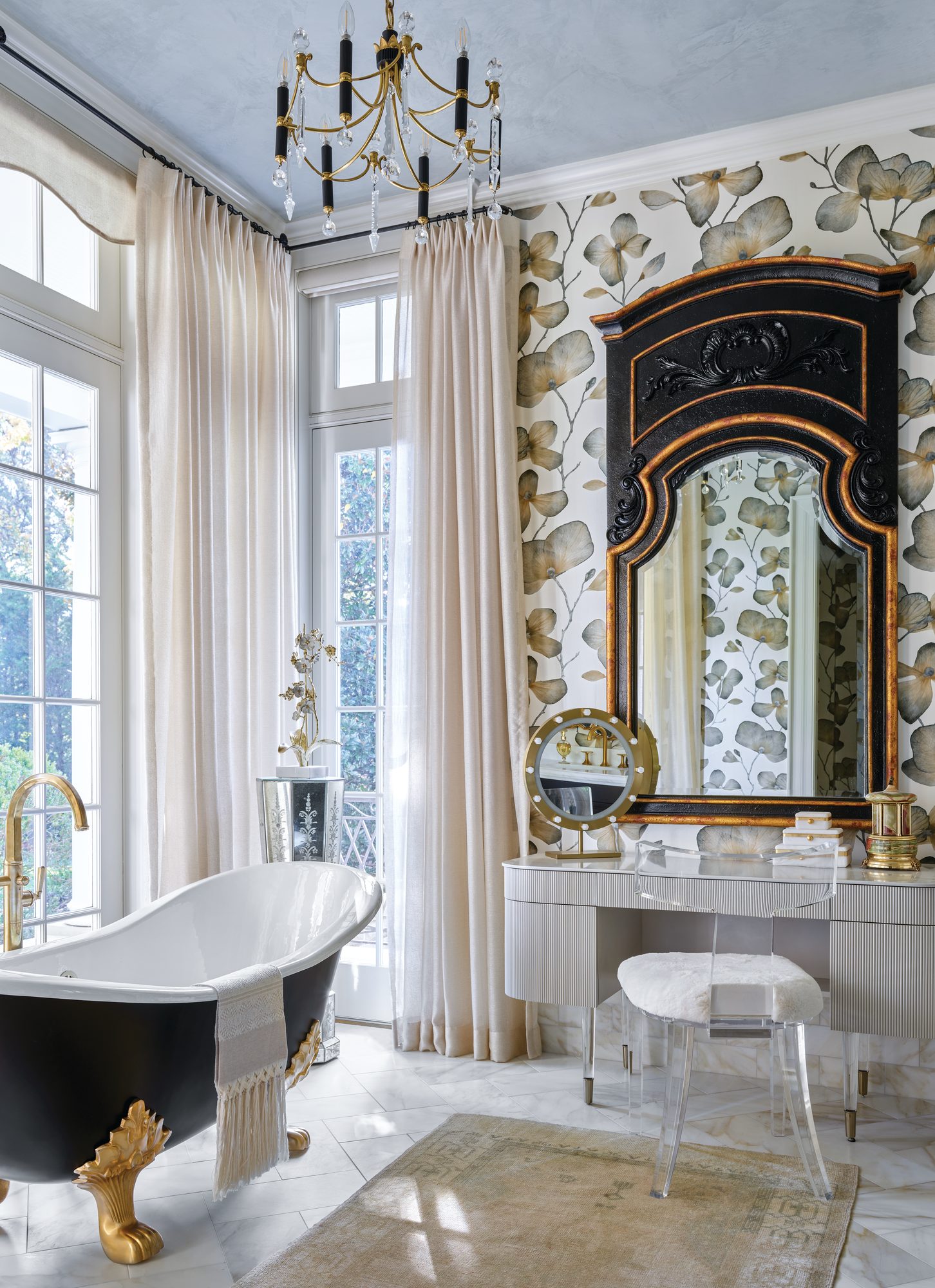 Primary bath with a black-and-gold claw-foot tub, floral wallpaper, and a gold-trimmed vanity mirror
