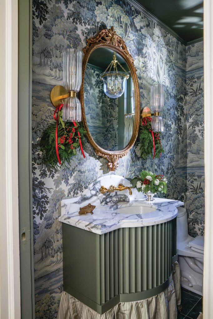 Powder room with a fluted wall-mounted vanity, House of Hackney wallcovering, antique gilt mirror, and Visual Comfort sconces