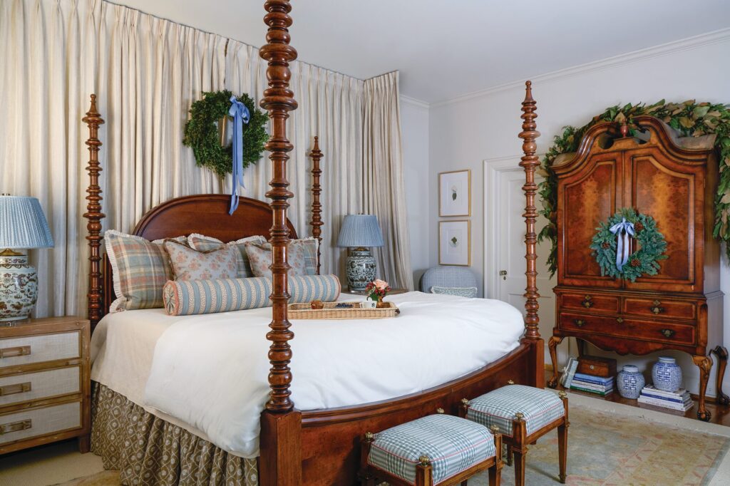 Primary bedroom with Ballet White walls, a richly stained poster bed, antique highboy, and holiday wreaths