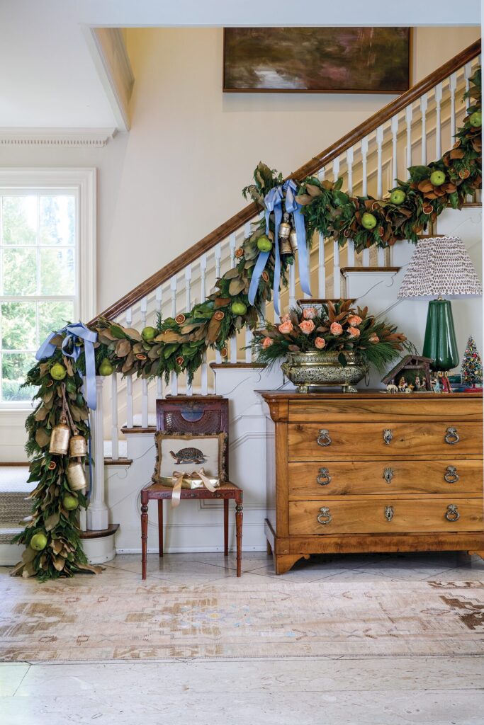 Staircase garland with fresh pears, apples, dried citrus, and blue ribbon in the Colonial Williamsburg style