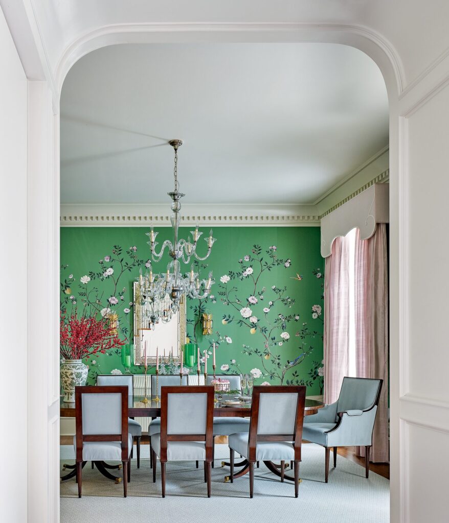 Formal dining room with a green Scalamandré wallpaper mural, pink draperies, and a crystal chandelier