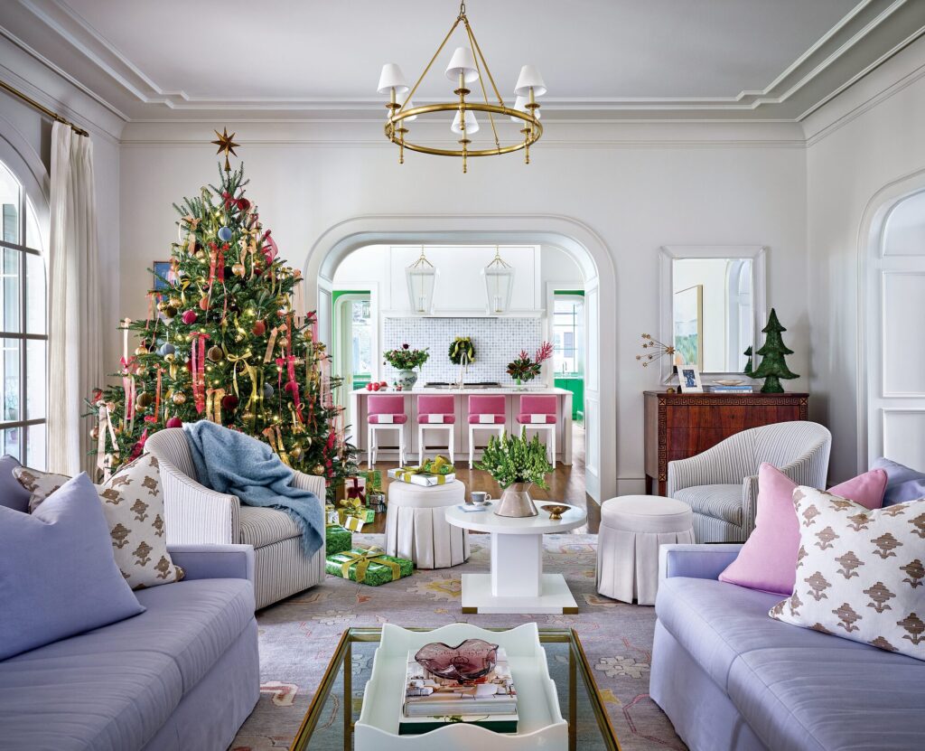Family room with lavender sofas and swivel chairs open to the kitchen, with a decorated Christmas tree