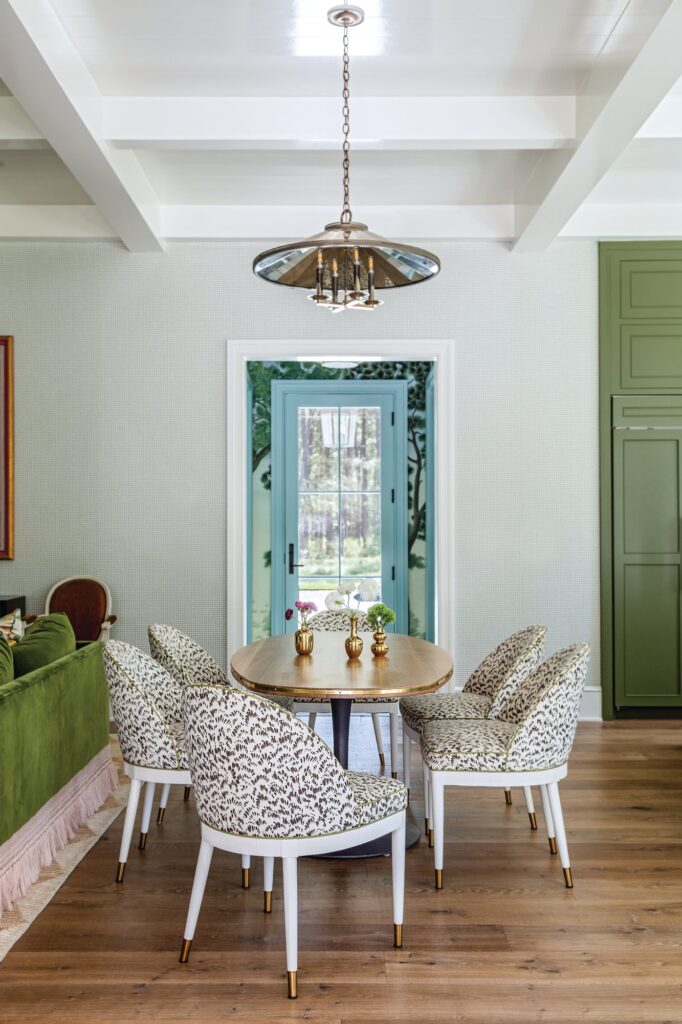 Dining nook with a round wood table, animal-print upholstered chairs, and a vintage-style pendant from The Urban Electric Co.