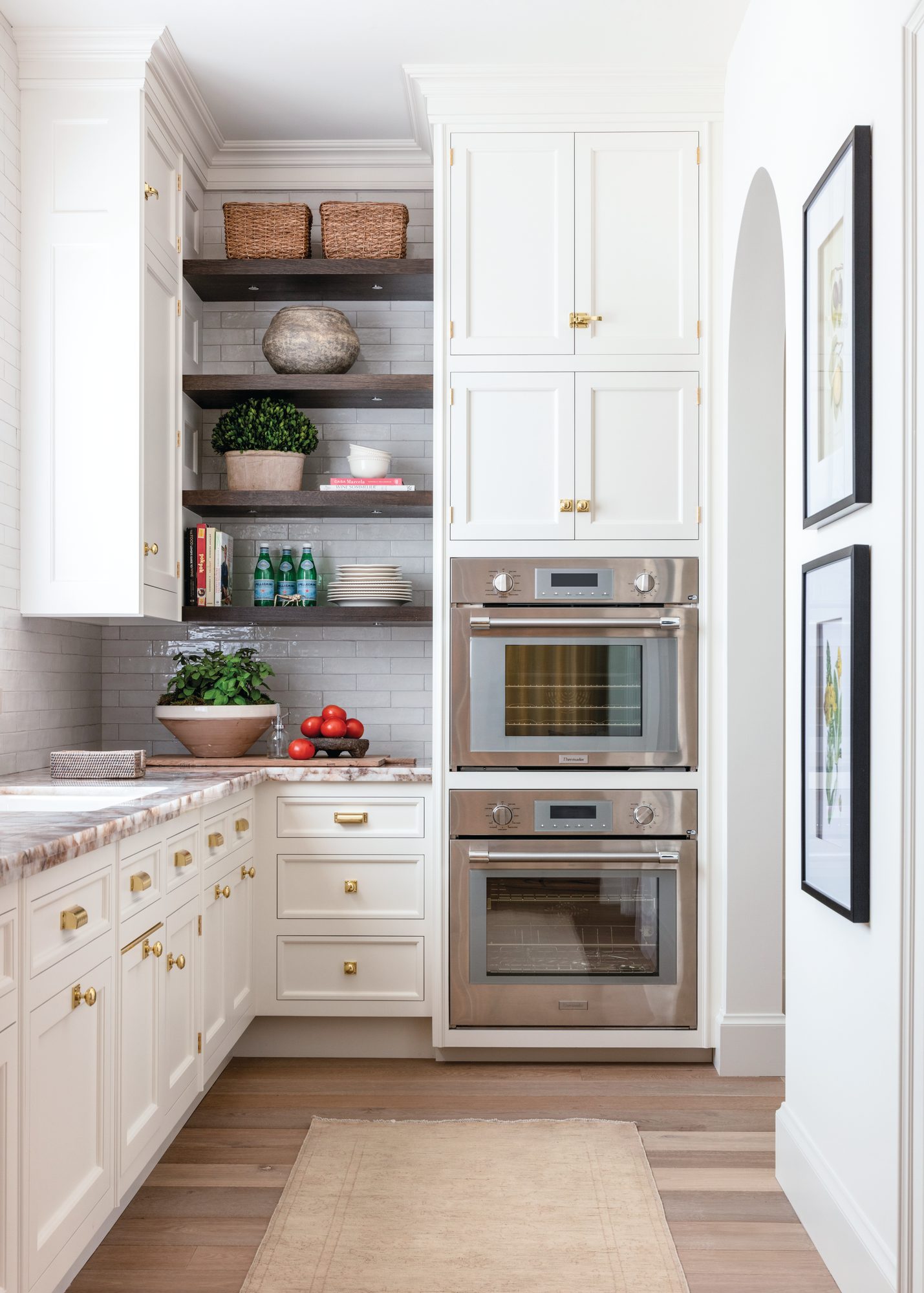 Overflow prep kitchen and pantry with white cabinetry, open shelving, double wall ovens, and a second sink