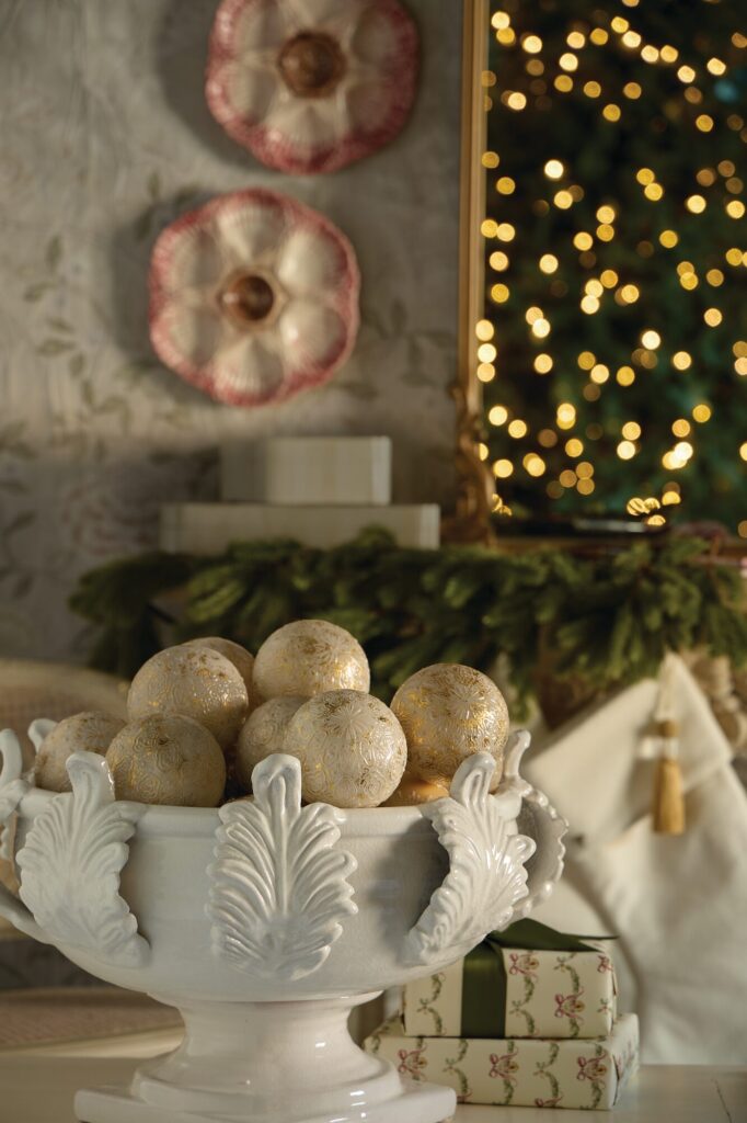Abigail’s Vinci acanthus leaf centerpiece in glazed white terra-cotta filled with gilded ornaments on a holiday mantel